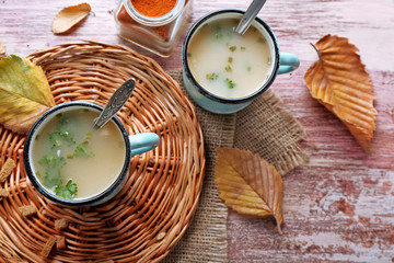 Mugs of soup on wicker mat