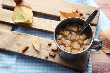 Mug of soup on wooden mat