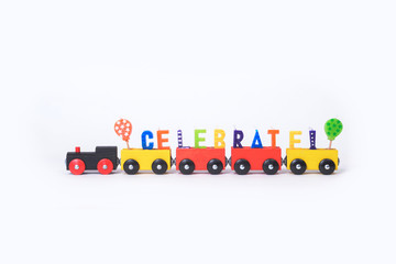 Toy train with colorful letters on top arranged in word celebrat