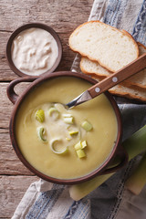 Leek cream soup in bowl close-up on the table. Vertical top view
