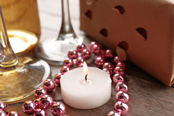 Setting of a bottle of wine, a gift in the box and other decoration, on wooden background