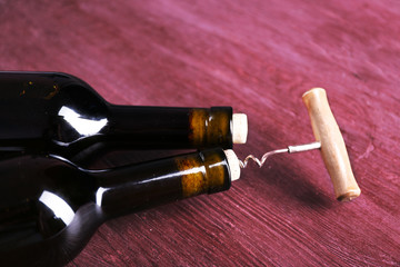 Two bottle wine and corkscrew on purple wooden background