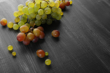 Juicy green and purple grapes, on wooden background