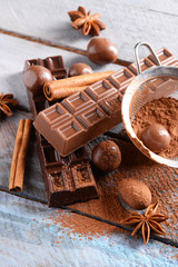 Chocolate sweets with powder on wooden background