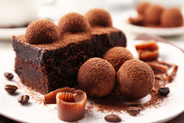 Slice of chocolate cake with a truffle on plate closeup