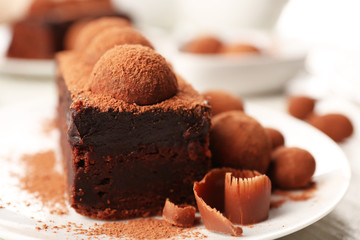 Slices of chocolate cake with a truffle on plate closeup