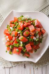 Salted salmon salad with vegetables close-up. vertical top view
