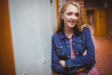 Fototapeta na wymiar Smiling student leaning against the locker