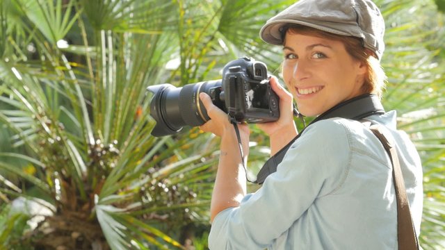 Woman photographer in park shooting nature