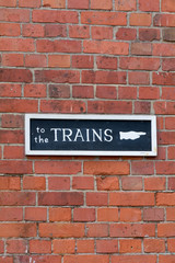 Fototapeta na wymiar To The Trains sign on wall at Railway Station