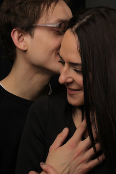 the young handsome man and the young attractive woman in the black embrace