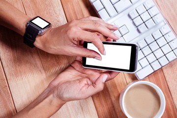 Feminine hands with smartwatch using smartphone