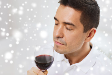 happy man drinking red wine from glass at home