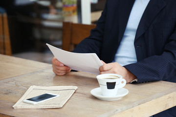 Businessman having lunch and working in a cafe, close-up