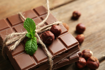 Black chocolate pieces with nuts on wooden background