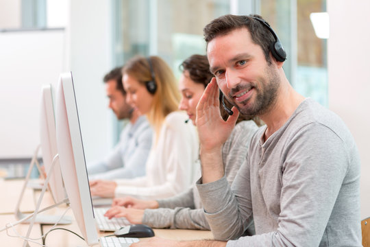 Young attractive man working in a call center
