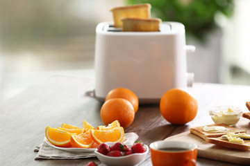 Served table for breakfast with toast, coffee and fruit, on blurred background
