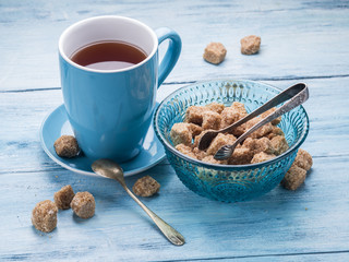 Cup of tea and cane sugar cubes.