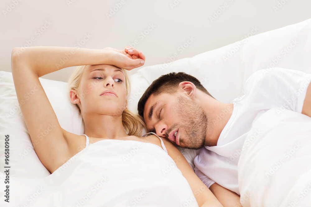 Wall mural couple sleeping in bed at home