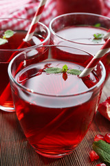 Three glasses of tasty garnet juice on the table, close-up