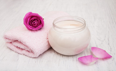 Fototapeta na wymiar spa essentials cream with towels and rose