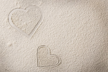 Hearts of flour on wooden background