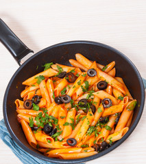 Penne pasta with tomato sauce in a frying pan