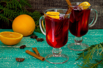 Mulled wine with decorated Christmas tree on a wooden table