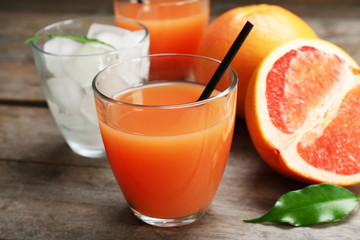 Citrus juice with ice and fresh fruits on wooden background