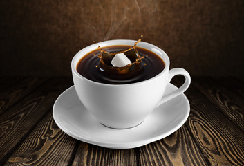 Cup of coffee and sugar on wooden background.