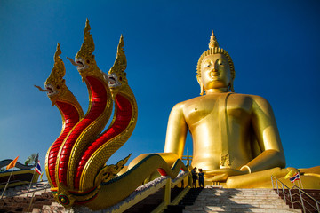 Obraz premium The largest golden Buddha with blue sky as a backdrop.