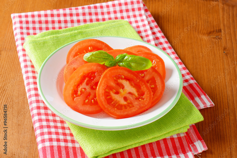 Sticker fresh tomato slices on plate