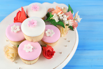 Tasty cupcakes on color wooden background