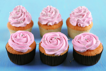 Tasty cupcakes on color wooden background