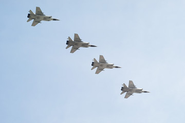 Mikoyan-Gurevich MiG-31 (Foxhound) supersonic interceptor aircrafts in row on blue sky background.