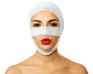 Young beautiful woman with a gauze bandage on her head and nose, isolated on white