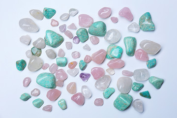 Pile of mineral stones: azonite, pink quartz, rock crystal isolated on white background