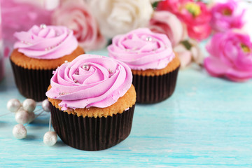 Tasty cupcakes and cup of tea on light background