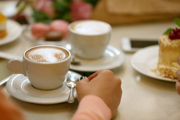 Woman with a cup of coffee and cake in cafe