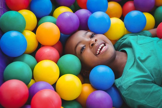 Smiling boy playing in sponge ball pool
