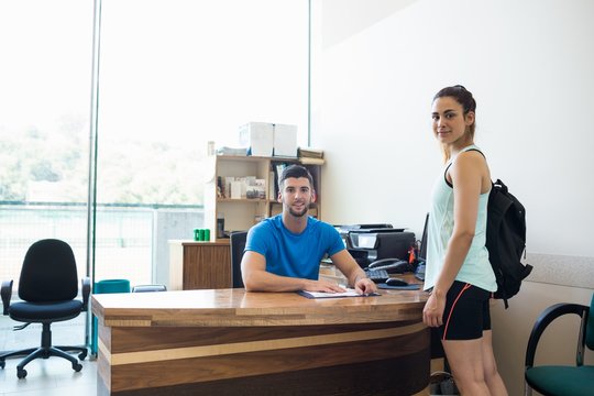 Athletic woman talking with fitness trainer