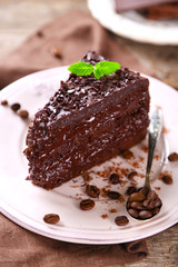 Chocolate cake with chocolate cream and fresh berries on plate, on wooden background