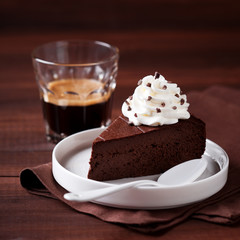 Piece of dark chocolate cake with whipped cream, selective focus