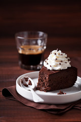 Piece of dark chocolate cake with whipped cream, selective focus