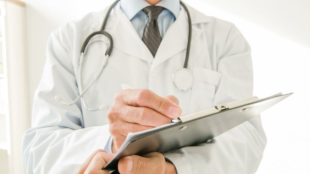 Doctor using clipboard to write.