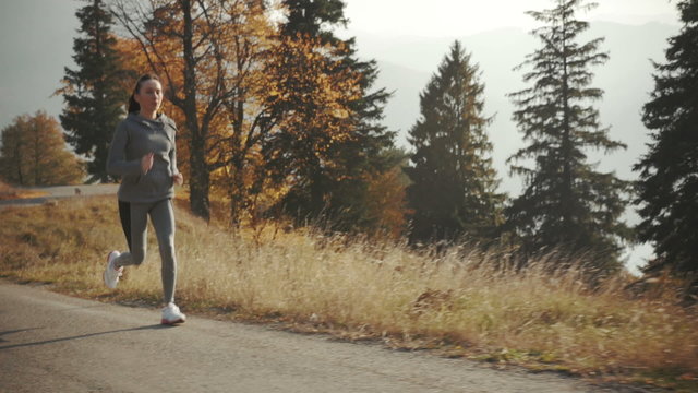 Female athlete running on forest road 