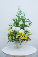 Artificial flowers bouquet in vase on the table