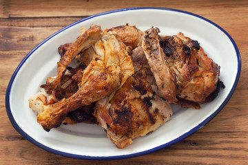 grilled chicken on white dish on brown wooden background