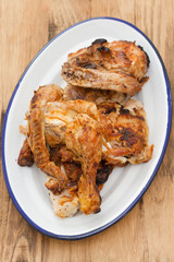 grilled chicken on white dish on brown background