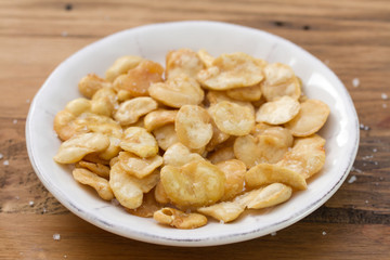 fried beans in white bowl on brown wooden background